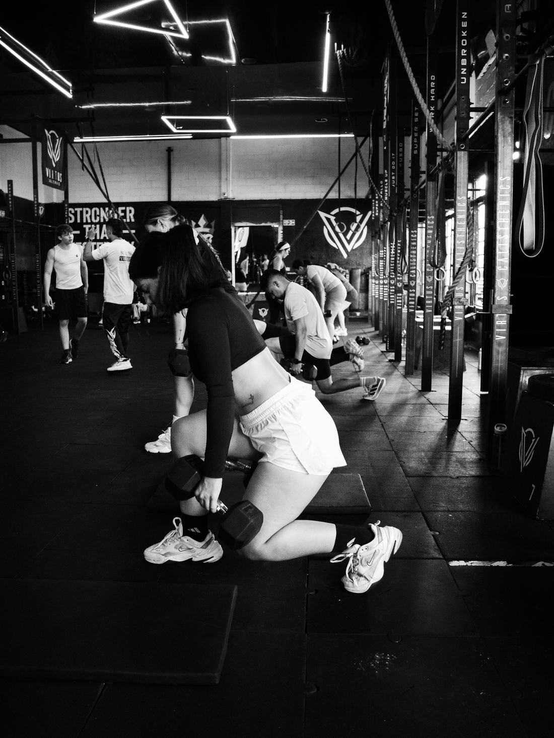 Clase en el box de Virtus: zona de entrenamiento con racks y mural de la marca